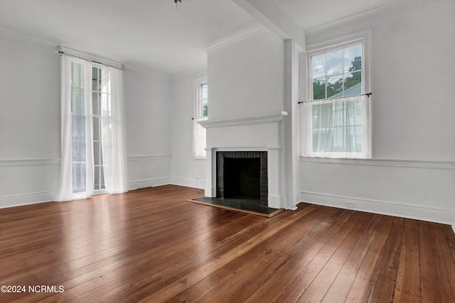 unfurnished living room with dark wood-type flooring and a brick fireplace