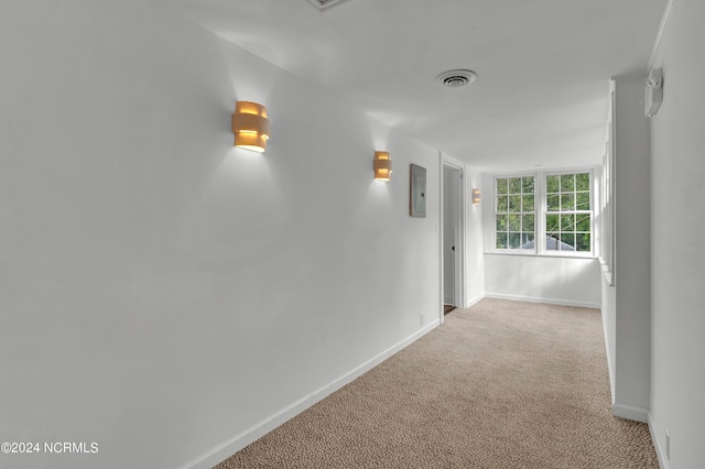 hallway with light carpet and electric panel