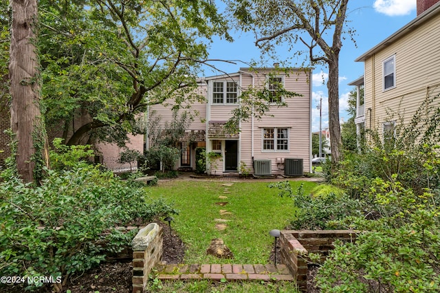 back of house with central AC and a yard