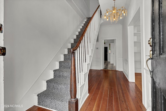 entryway featuring ornamental molding, dark hardwood / wood-style flooring, and a chandelier