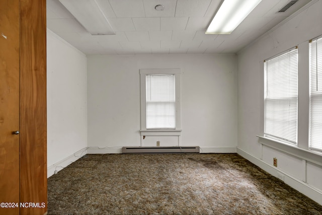 carpeted empty room with plenty of natural light and a baseboard heating unit