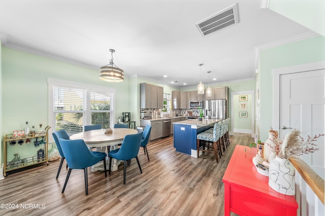 dining room featuring recessed lighting, visible vents, wood finished floors, and ornamental molding