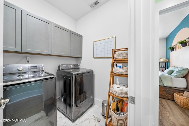 1305 Mackerel Ln Unit 1, Carolina Beach, NC 28428 - washroom featuring cabinet space, washing machine and dryer, and light marble finish floors