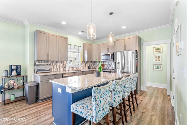 1305 Mackerel Ln Unit 1, Carolina Beach, NC 28428 - kitchen with stainless steel appliances, light wood-style flooring, decorative backsplash, a breakfast bar area, and a center island