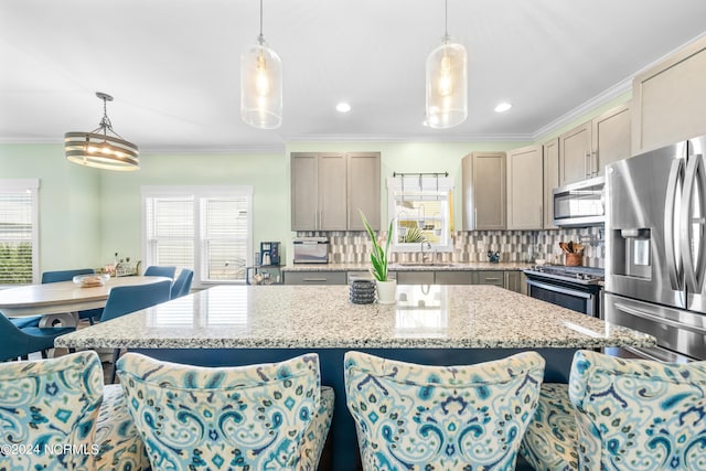 1305 Mackerel Ln Unit 1, Carolina Beach, NC 28428 - kitchen with stainless steel appliances, a kitchen bar, tasteful backsplash, ornamental molding, and light stone counters