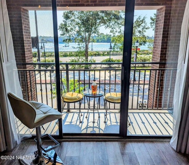 doorway to outside with hardwood / wood-style floors and a water view