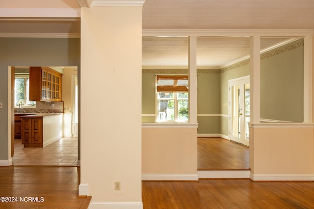 interior space featuring ornamental molding, sink, and light hardwood / wood-style flooring