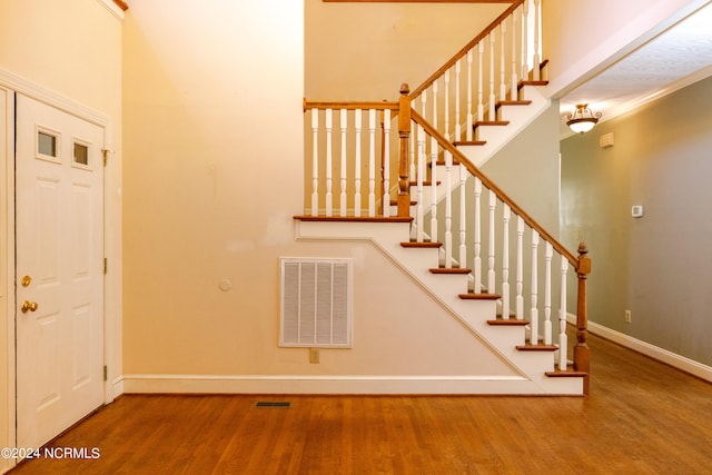 stairs featuring crown molding and wood-type flooring