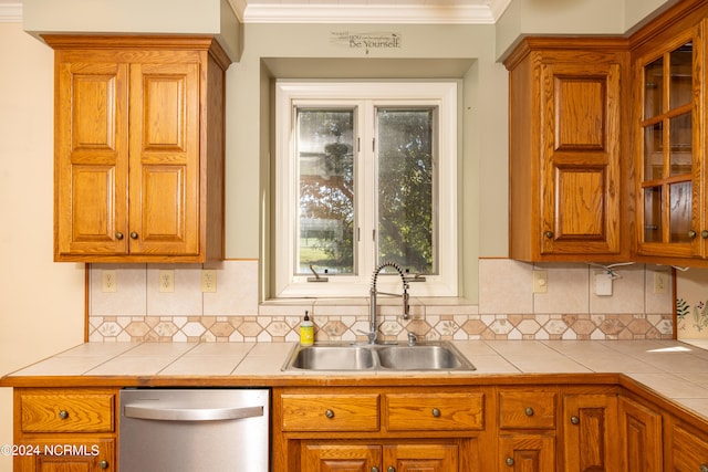 kitchen with dishwasher, tasteful backsplash, tile counters, and sink