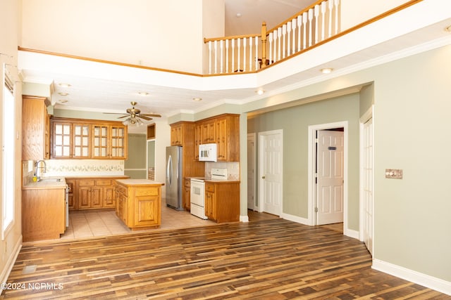 kitchen with crown molding, light hardwood / wood-style flooring, a center island, and white appliances