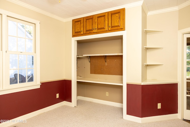 interior space featuring light carpet, built in desk, and ornamental molding