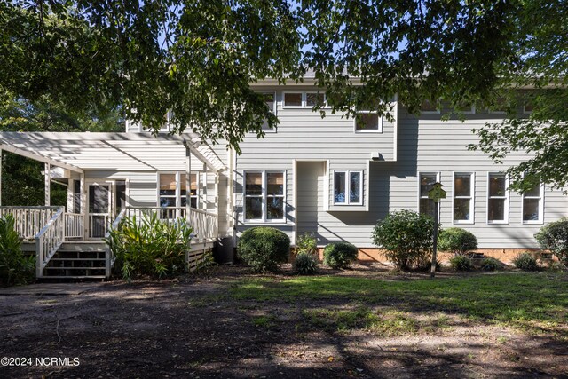 view of front of property featuring a pergola and a wooden deck