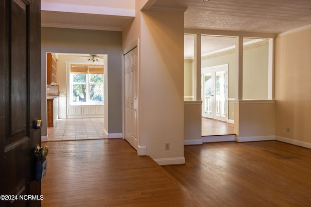 interior space featuring light wood-type flooring, ceiling fan, and ornamental molding