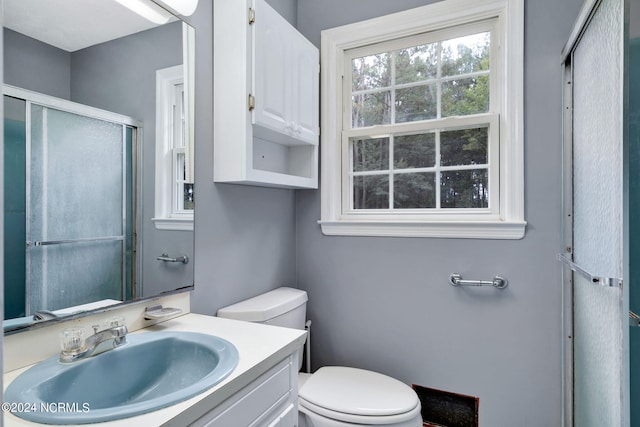 bathroom featuring vanity, toilet, and an enclosed shower