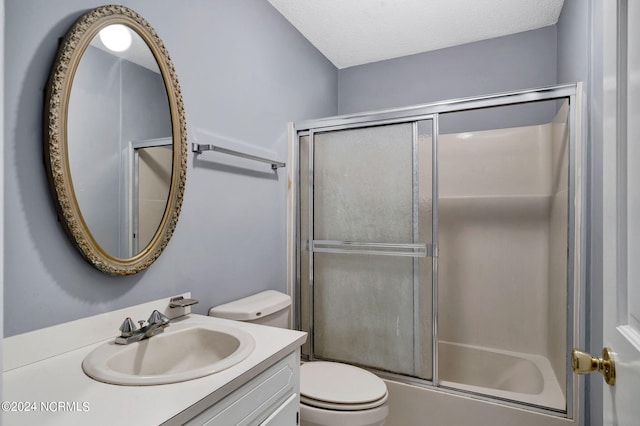 full bathroom featuring a textured ceiling, bath / shower combo with glass door, vanity, and toilet