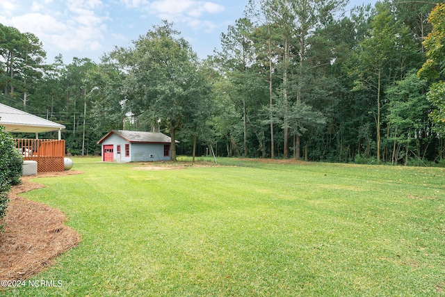 view of yard featuring a wooden deck and an outbuilding