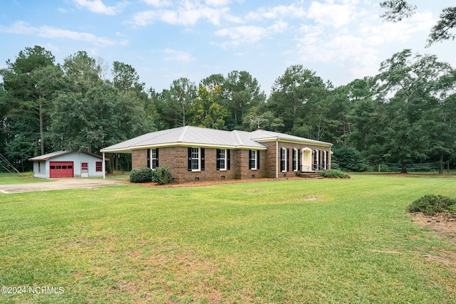 single story home with a front yard, a garage, and an outbuilding