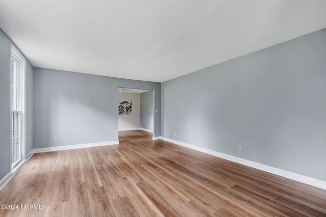 unfurnished room with a textured ceiling and light hardwood / wood-style flooring