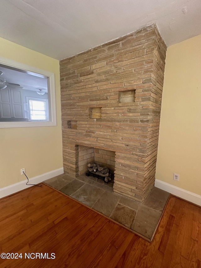 interior details with a large fireplace and hardwood / wood-style flooring