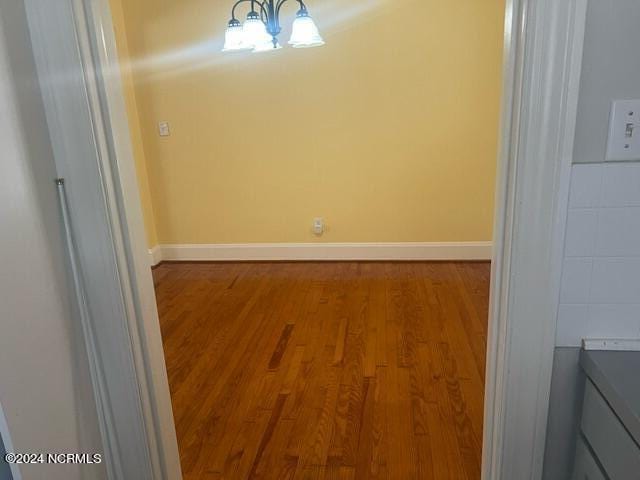 unfurnished dining area with baseboards and wood finished floors