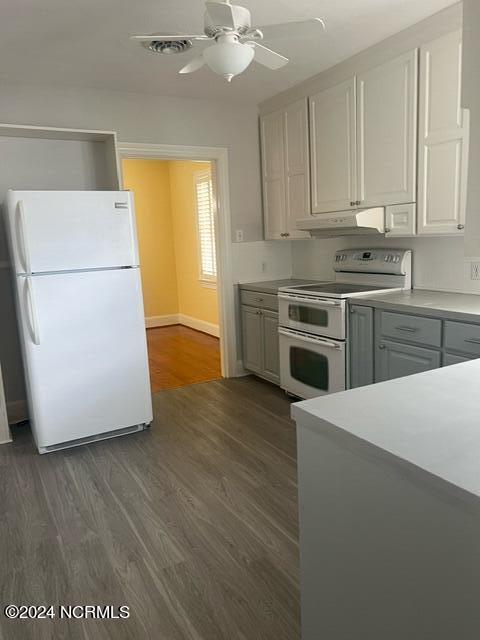 kitchen featuring ceiling fan, white appliances, light countertops, dark wood finished floors, and under cabinet range hood