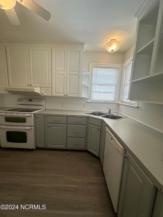kitchen featuring open shelves, dark wood finished floors, a sink, under cabinet range hood, and white appliances