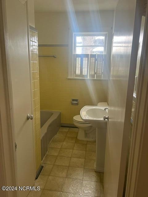 bathroom with tile walls and toilet