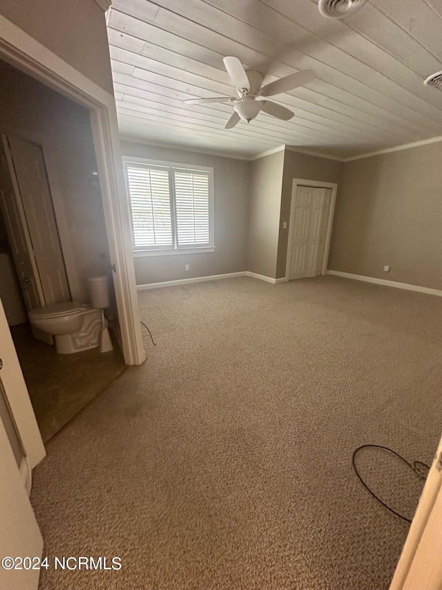 empty room featuring carpet flooring, a ceiling fan, baseboards, wooden ceiling, and ornamental molding