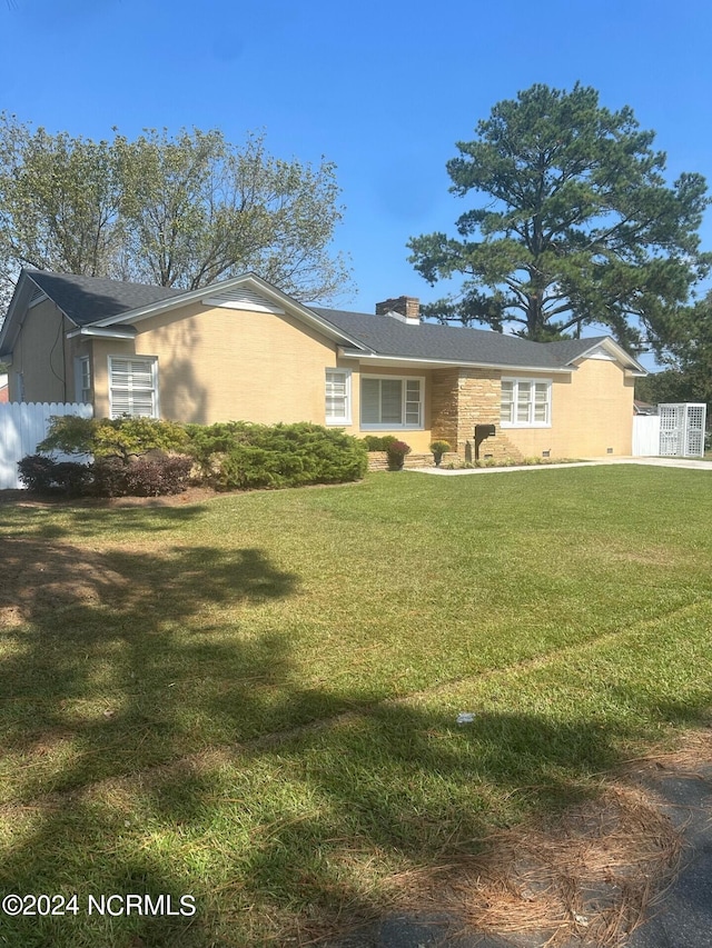 single story home featuring fence, a chimney, and a front yard