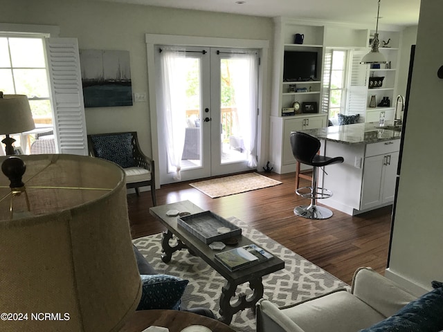 living room with french doors, sink, and dark hardwood / wood-style flooring