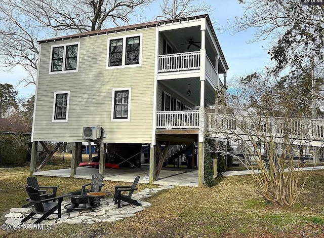 back of house featuring a patio, a yard, a balcony, a fire pit, and ac unit