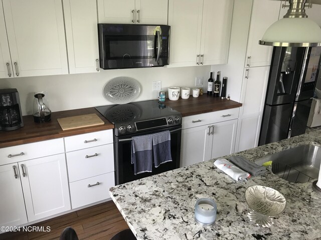 kitchen with white cabinets, wood counters, range with electric cooktop, and dark hardwood / wood-style flooring