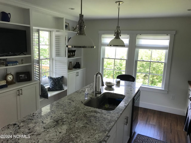 kitchen with white cabinets, light stone countertops, pendant lighting, dark hardwood / wood-style floors, and sink