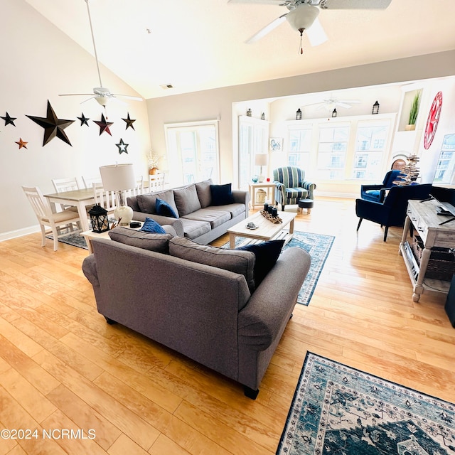 living room featuring light hardwood / wood-style floors, ceiling fan, and vaulted ceiling