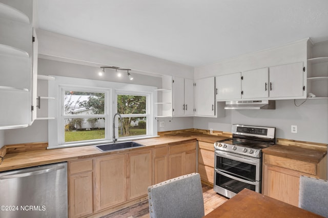 kitchen with stainless steel appliances, wood counters, sink, and extractor fan