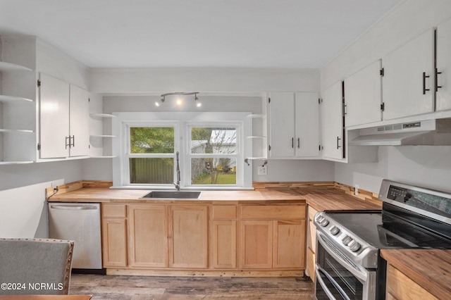 kitchen featuring white cabinetry, butcher block counters, appliances with stainless steel finishes, and light hardwood / wood-style flooring