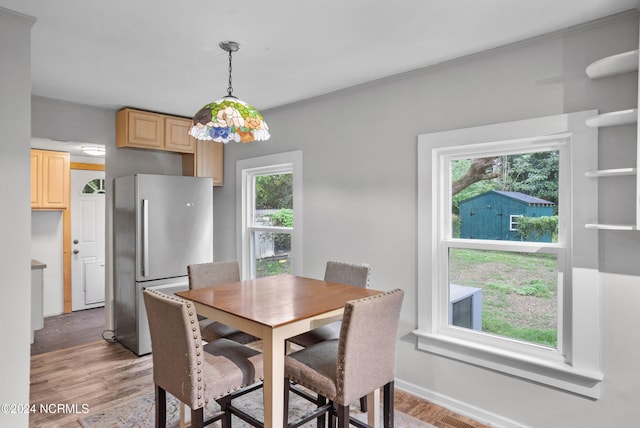 dining space with crown molding and hardwood / wood-style flooring