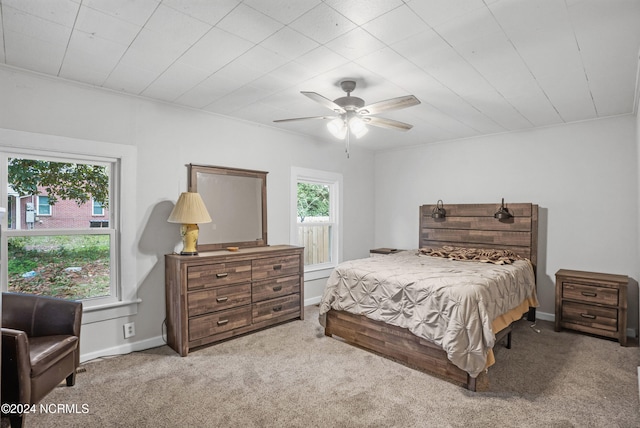 carpeted bedroom featuring ceiling fan and multiple windows