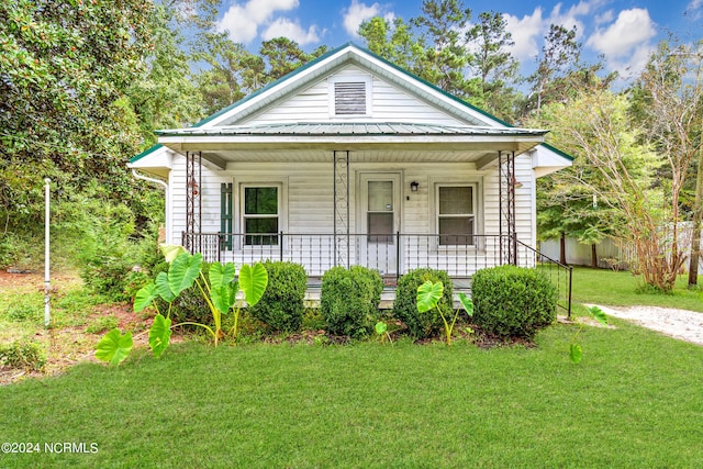 bungalow featuring a porch and a front lawn