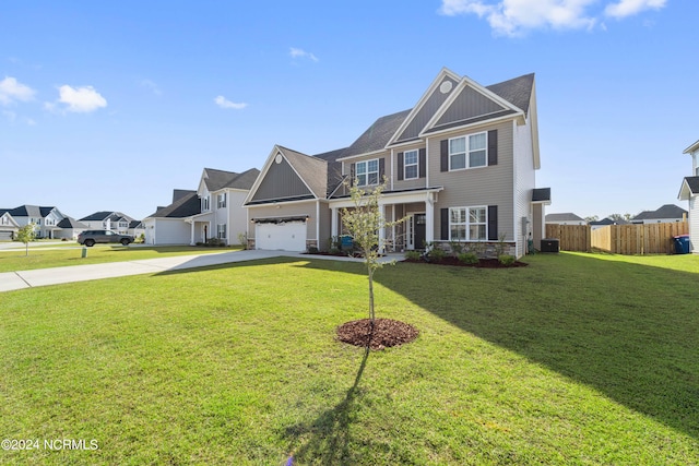 view of front of home featuring a front yard, a garage, and central AC