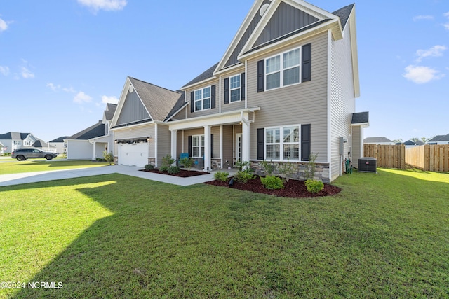 craftsman inspired home featuring a garage, a front lawn, and central air condition unit