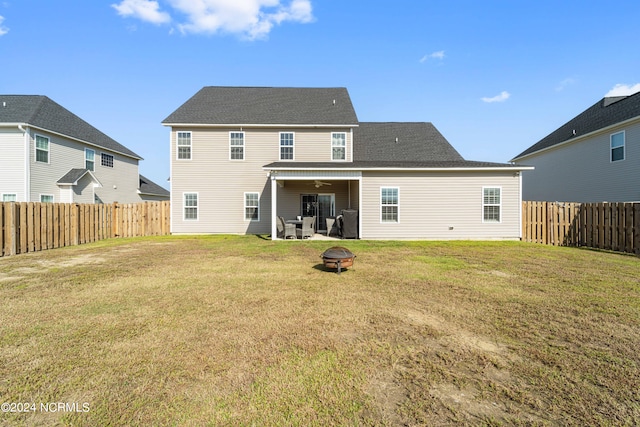 rear view of property featuring a yard and a patio area