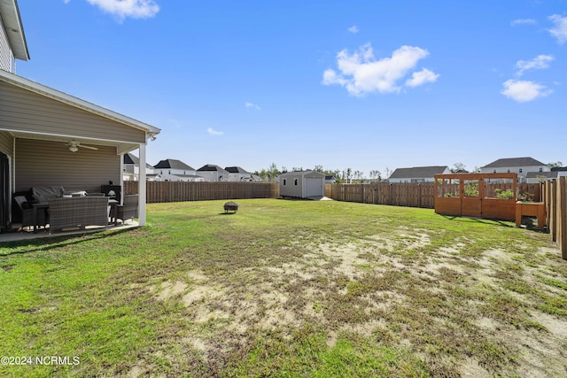 view of yard featuring a shed, an outdoor living space, and a patio area