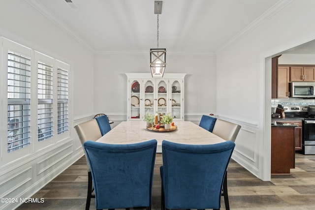 dining space with ornamental molding and dark hardwood / wood-style flooring