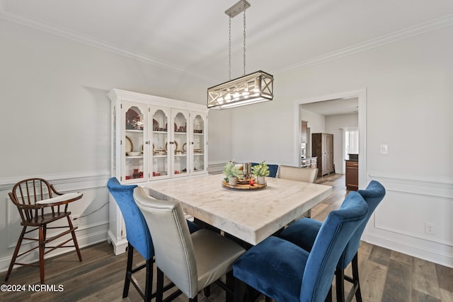 dining area with ornamental molding and dark hardwood / wood-style flooring