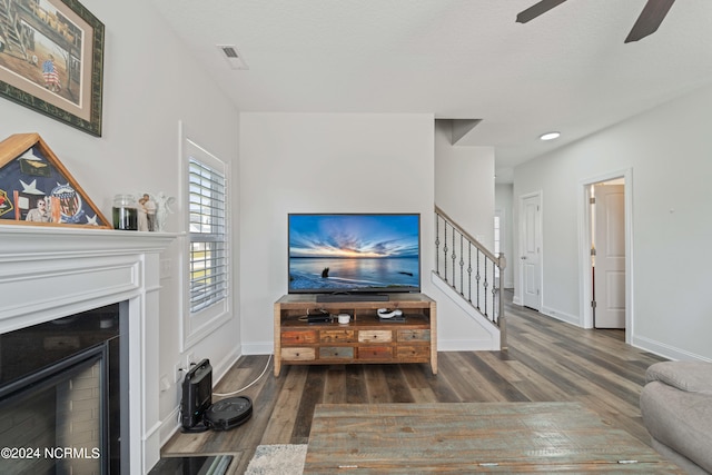 living room featuring ceiling fan and dark hardwood / wood-style flooring