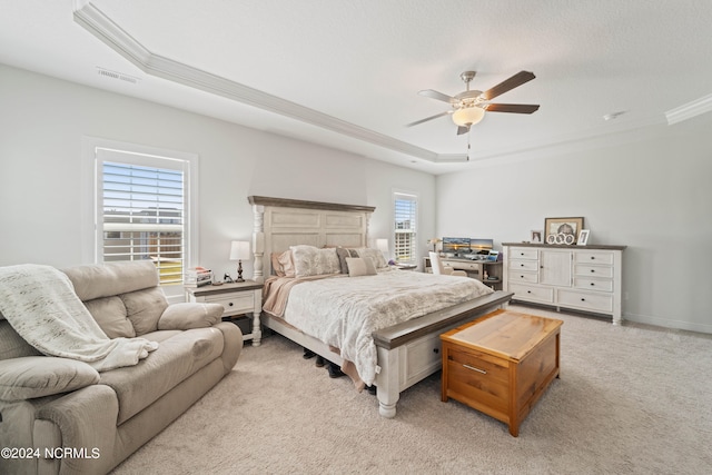 carpeted bedroom featuring ceiling fan, a raised ceiling, and ornamental molding