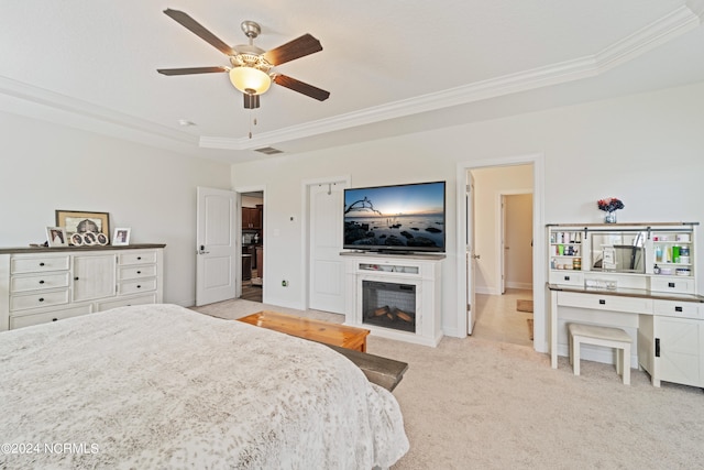 bedroom featuring light colored carpet, ceiling fan, a raised ceiling, and crown molding