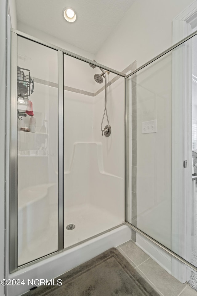 bathroom featuring tile patterned flooring and a shower with shower door