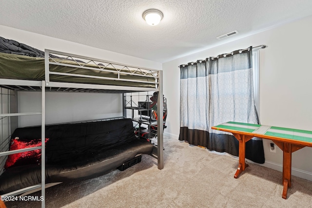 bedroom featuring carpet and a textured ceiling